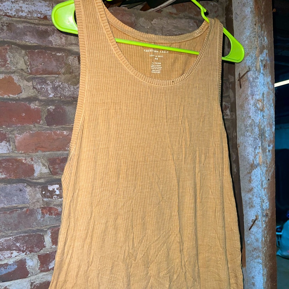 American eagle tank top. It’s on the longer side. Not fitted. Mustard color. New